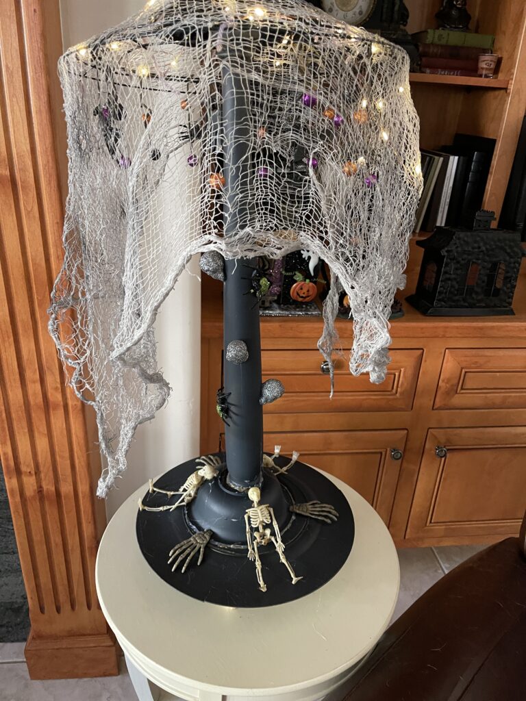 Black Halloween floor lamp  with black cheesecloth hanging over the top.